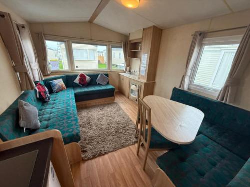 una sala de estar con un sofá y una mesa en JTD golden gate caravan park towyn hire, en Kinmel Bay