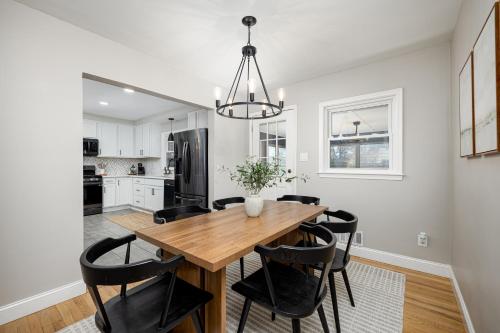 a kitchen and dining room with a wooden table and black chairs at Main Street Retreat Hot Tub Sleeps 8 in Plymouth