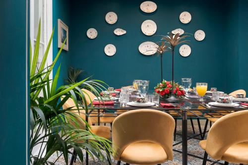 a dining room with a table and clocks on the wall at Palazzo Arone dei Baroni di Valentino in Palermo