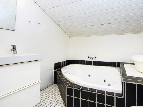 a bathroom with a bath tub and a sink at 12 person holiday home in Fanø-By Traum in Fanø