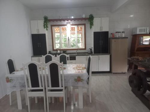 een keuken met een tafel en stoelen en een keuken met een raam bij Sitio Daniela in São João Batista