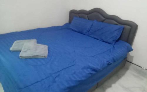 Cama azul con sábanas y almohadas azules en Serenity House khlongnin, en Phra Ae beach