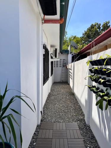 a walkway between two white walls with plants at RKs Cozy Balai in General Santos