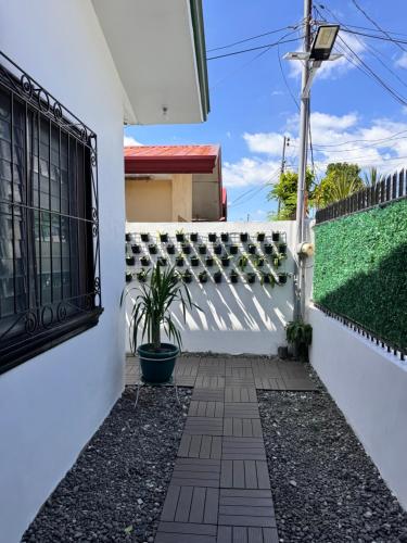 a white fence with a gate and a plant at RKs Cozy Balai in General Santos