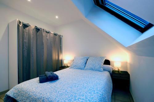 Un dormitorio con una cama con almohadas azules. en Welcome Home, en Vert-le-Grand