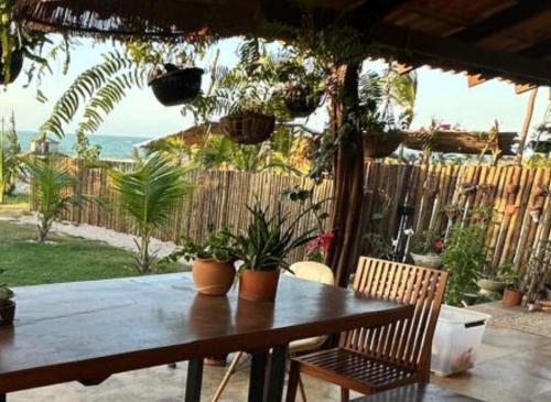 einen Holztisch mit Pflanzen auf einer Terrasse in der Unterkunft Refúgio prea in Cruz