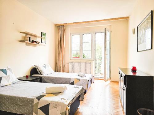 a hotel room with two beds and a window at Mother Teresa Apartments in Skopje