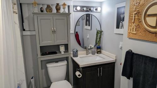 a bathroom with a toilet and a sink and a mirror at Chic Japanese Vibe Smart Home- Liberty Village 10 min walk to CNE & GO Station in Toronto