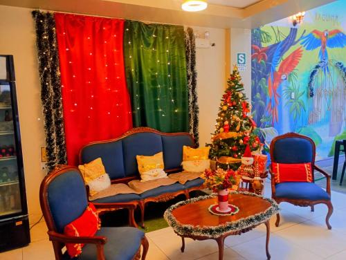 a living room with a couch and a christmas tree at Mi Quinta Raíz Loft Apartments in Iquitos