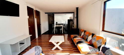 迈滕西约Cabaña El Hibisco的客厅里有一张沙发和一张桌子。