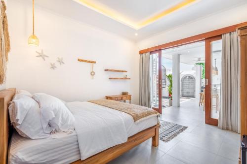 a bedroom with white walls and a bed in a room at Boho Majipso Dreamy in Munggu
