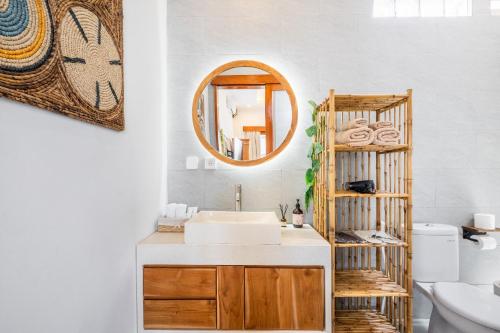 ein Badezimmer mit Waschbecken und Spiegel in der Unterkunft Boho Majipso Dreamy in Munggu