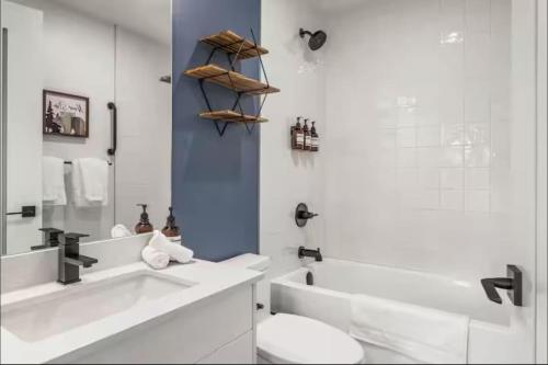 a white bathroom with a sink and a toilet at Luxury 2 Bedroom Mountain View Condo in Canmore