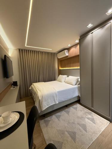 Studio Novo Moderno e Aconchegante - Centro في باراناغوا: غرفة نوم صغيرة مع سرير وطاولة