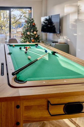 a pool table in a living room with a christmas tree at Luxury Stay, City Walk, Pool Table & Air Hockey, Garden, Parking, Business & Families - Oakview in Colchester