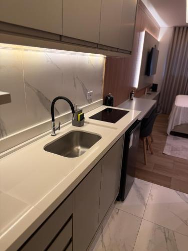 a kitchen with a sink and a counter at Studio Novo Moderno e Aconchegante - Centro in Paranaguá