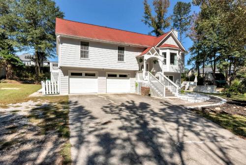 Casa blanca con techo rojo y entrada en Spacious 5BR Family Retreat Near Mall of GA Sleeps 13, en Buford