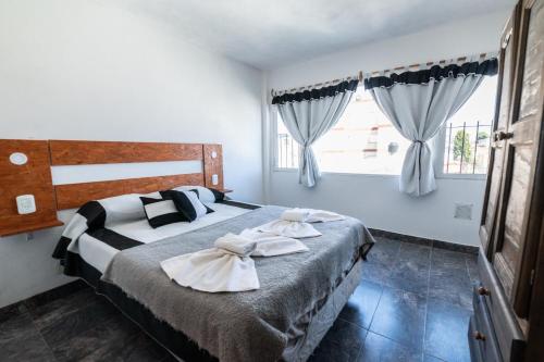 Palmeras Departamentos في سانتا تيريسيتا: غرفة نوم بها سرير كبير مع مناشف عليه