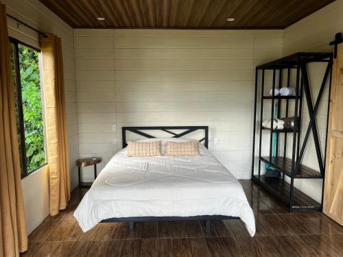 UpalaにあるCabaña Colibríの白いシーツと窓のあるベッドのある寝室