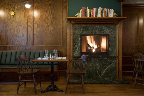 Auberge Willow Inn في Hudson: مطعم فيه موقد وطاولة وكراسي
