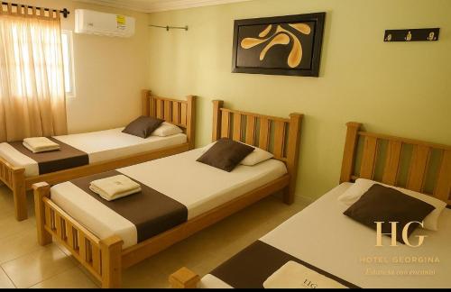 巴兰基亚Hotel Georgina的一间卧室，墙上有两张床和一幅画