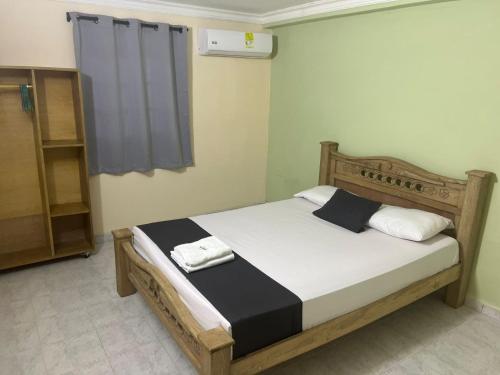 巴兰基亚Hotel Georgina的一间卧室配有一张带白色和黑色床单的床