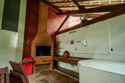 a kitchen with a brick fireplace in a room at Apartamento Riviera na Praça das Artes Módulo 6 in Riviera de São Lourenço