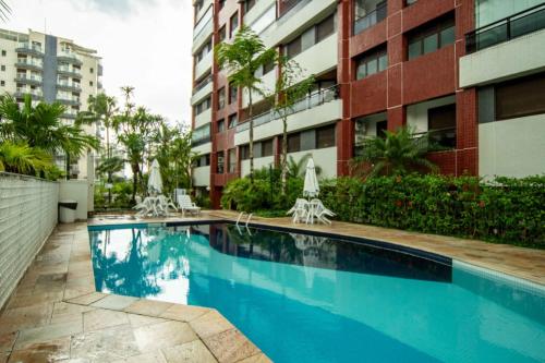a swimming pool in front of a building at Apartamento Riviera na Praça das Artes Módulo 6 in Riviera de São Lourenço