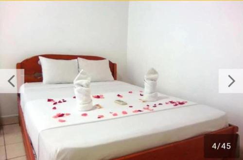 a bedroom with a bed with flowers on it at Hotel Perezoso in Iquitos