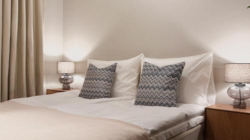 ein Schlafzimmer mit einem Bett mit zwei Kissen und zwei Lampen in der Unterkunft Design home with sauna and spa in central Helsinki in Helsinki