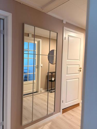 a mirror in a room with a door at Kirkevegen apartment in Brumunddalen