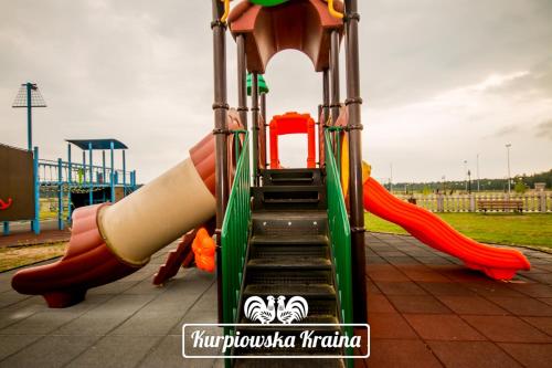 a slide at a playground with a water slide at Kurpiowska Kraina in Wydmusy