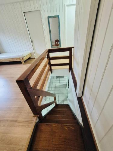 una scala in legno in una stanza con specchio di Cabana Amarela Guarda do Embaú a Palhoça