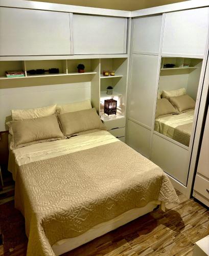 a bedroom with a bed and a mirror at Aconchegante Casa na vila de pescadores in Baixio