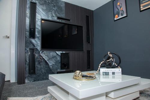 a living room with a tv and a white table at One-bedroom guest suite with private entry in Winnipeg