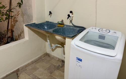 Un baño con lavabo y lavadora. en Casa na vila de pescadores de Baixio, en Baixio
