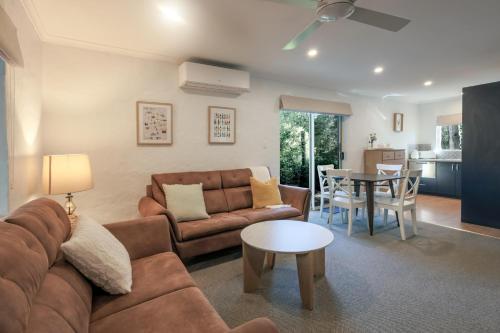 a living room with a couch and a table at Donnybrook Cottages - Hutt River in Clare