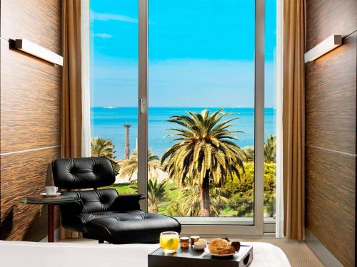 a black chair in a room with a view of the ocean at Swissotel Buyuk Efes Izmir in Izmir