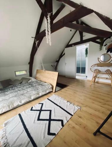 a bedroom with a bed and a wooden floor at Le grand Brandonné in Loiré