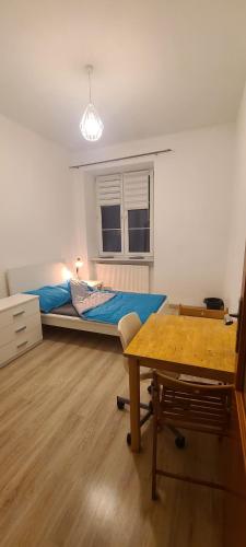 Centrally located cozy apartment في كراكوف: غرفة بسرير ومكتب وطاولة