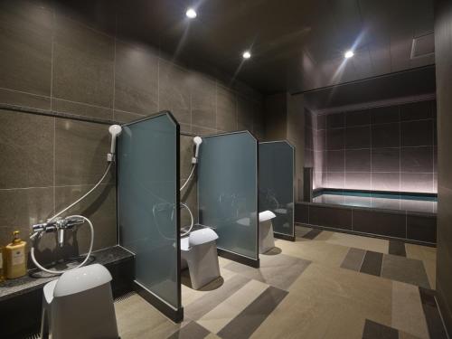 a bathroom with two toilets and a bath tub at Premium hotel MONday MAIHAMA View 1 in Tokyo