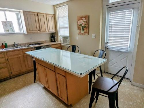 坎伯兰Relaxing Rustic Oasis II, Unit B - 6 minute walk to Downtown! Cyclists Welcome!的一个带玻璃台面的小岛的厨房