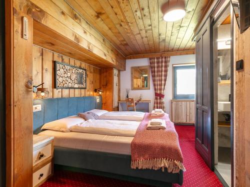 a bedroom with a bed in a room with wooden walls at Bergzeit Hollersbach XL in Hollersbach im Pinzgau