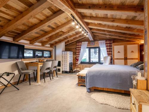 una camera da letto con un letto, un tavolo e delle sedie di Almversteck Hollersbach a Hollersbach im Pinzgau