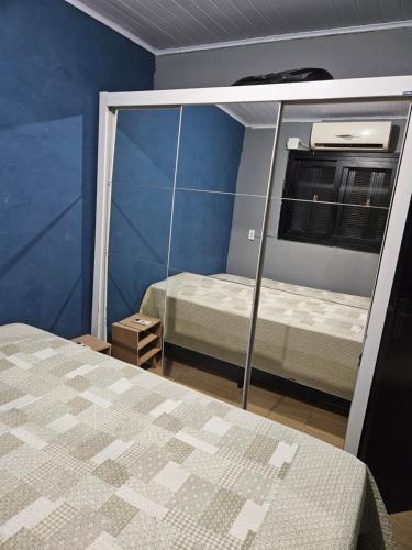 une petite chambre avec deux lits et une fenêtre dans l'établissement Casa da Família Flores, à Rosário do Sul