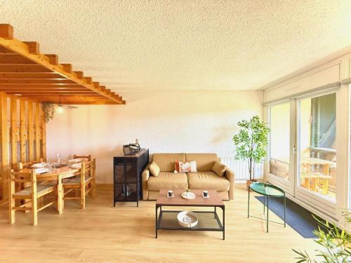 un soggiorno con un divano e un tavolo di Evasion Douce Désign a Prénatier