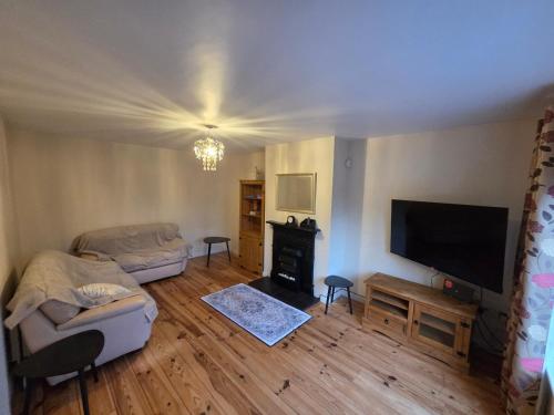 a living room with a flat screen tv and a couch at Eagle Valley , Wilton 4BR Extended Stays near CUH & UCC in Cork