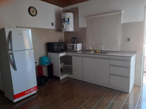 a kitchen with a white refrigerator and a sink at Depto La Punta in La Punta