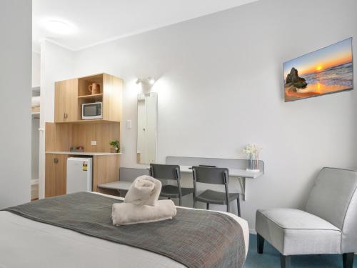 a room with a bed and a table and chairs at Bentleigh Motor Inn - Coffs Harbour in Coffs Harbour