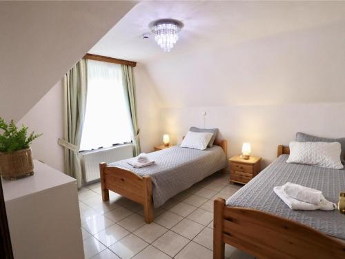 Un dormitorio con dos camas y una ventana. en Les Charmes, en Chevron